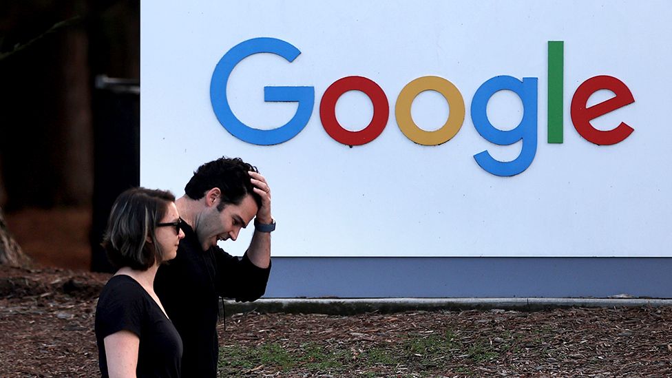 People walk past a Google sign in Mountain View, California on 30 January