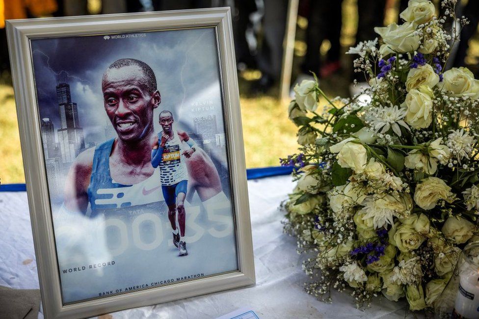 A picture of Kelvin Kiptum and a bouquet of flowers at the funeral.