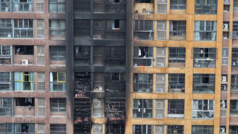 An aerial photo showing the blackened fronts of flats at the scene after the fire was extinguished