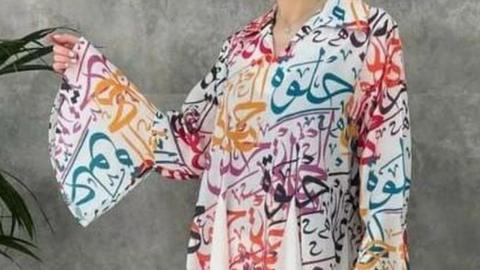 The dress has the word "Halwa" printed in Arabic letters on it, meaning sweet in Arabic