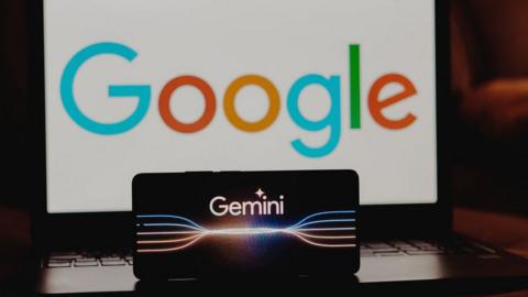 Photo illustration of the Google Gemini logo displayed on a smartphone screen with Google's logo in the background