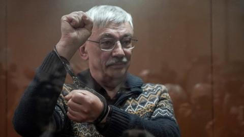 Oleg Orlov shows his handcuffs