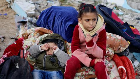 Children rest with belongings in Rafah